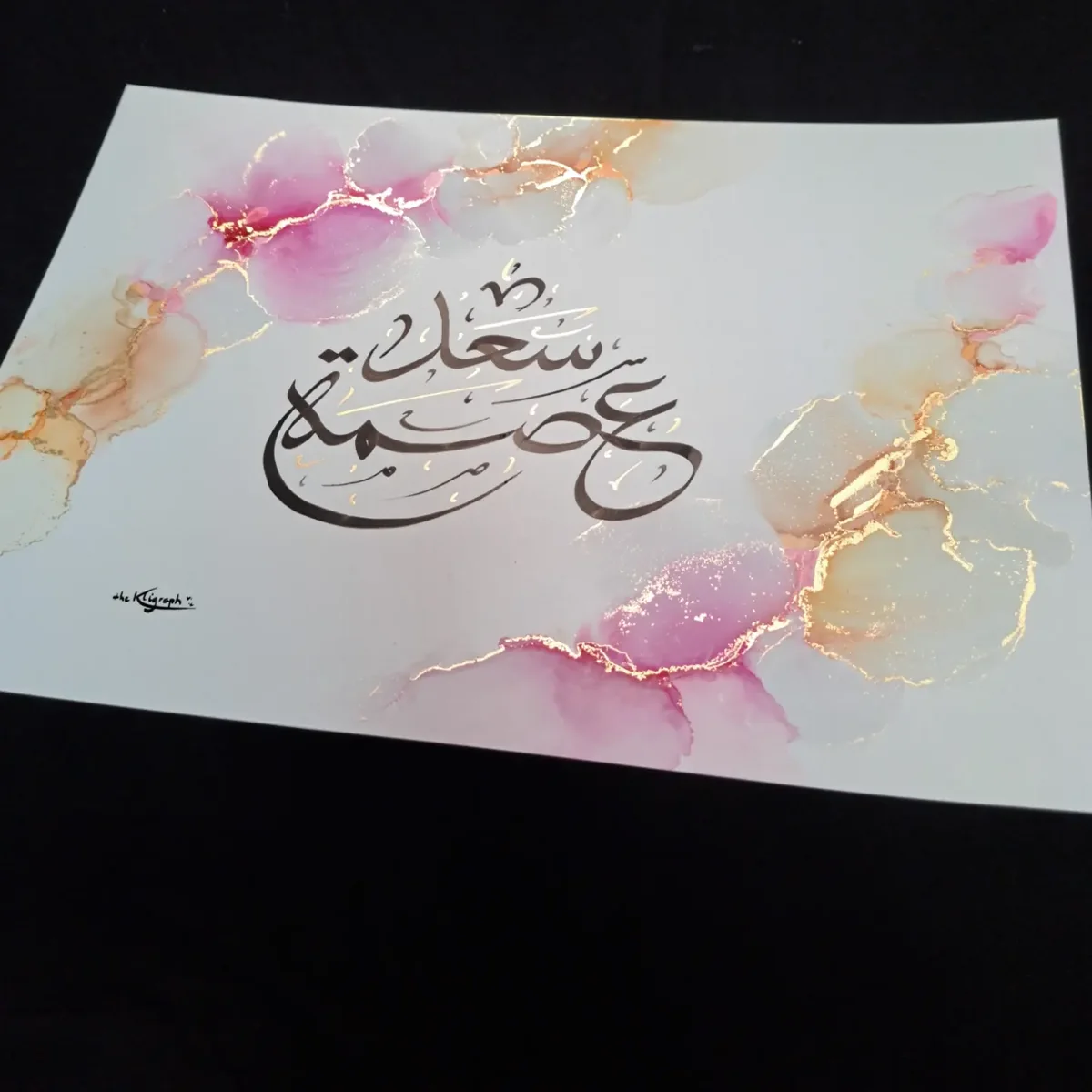 Arabic calligraphy of two first names with the reed pen, on pink and gold alcohol inks