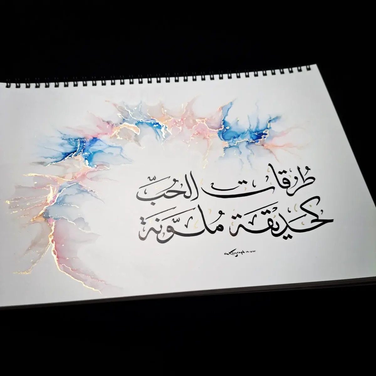 Arabic calligraphy over pink and blue inks, front view